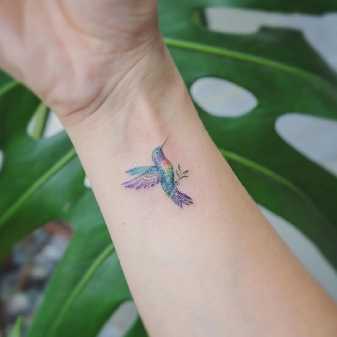 Fine line hummingbird tattoo on the wrist minimalistic